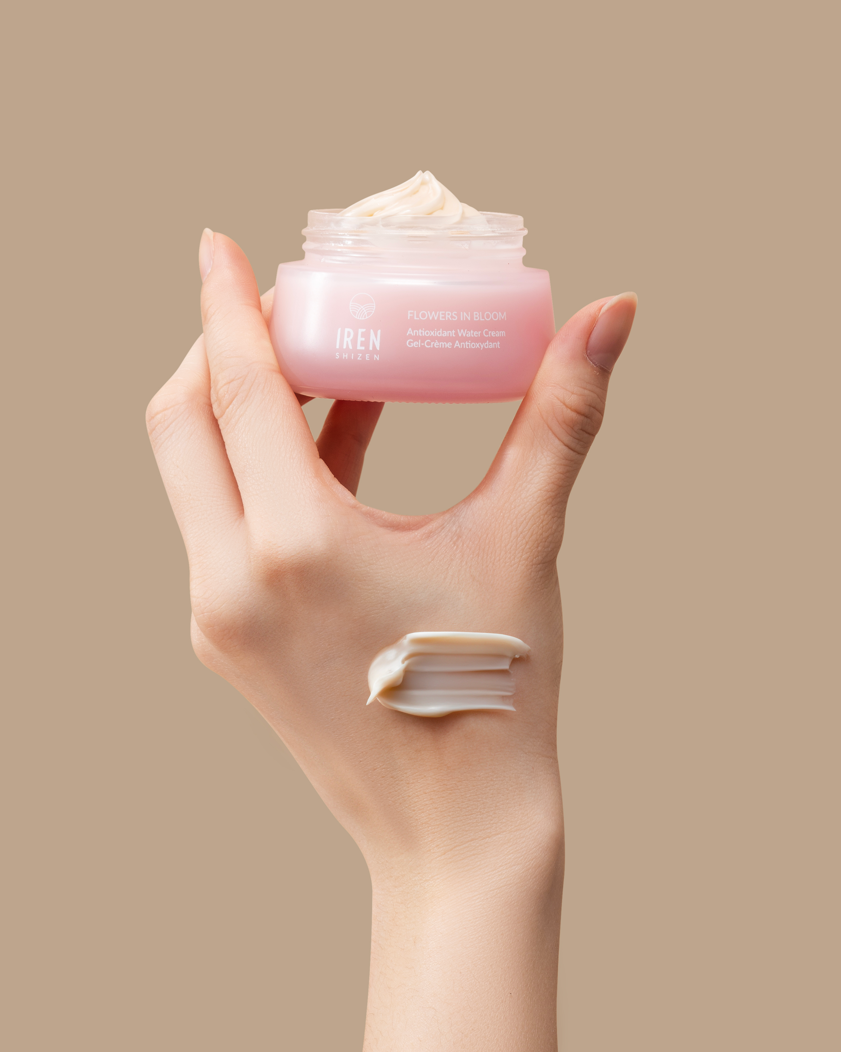 A hand holding a jar of FLOWERS IN BLOOM Antioxidant Water Cream by IREN Shizen. #all-groups