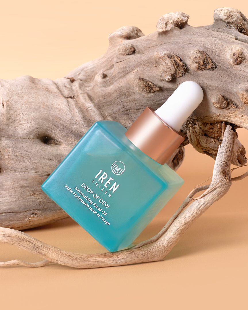 A bottle of Japanese customized skincare, DROP OF DEW Moisturizing Facial Oil, sitting on a piece of driftwood. #all-groups