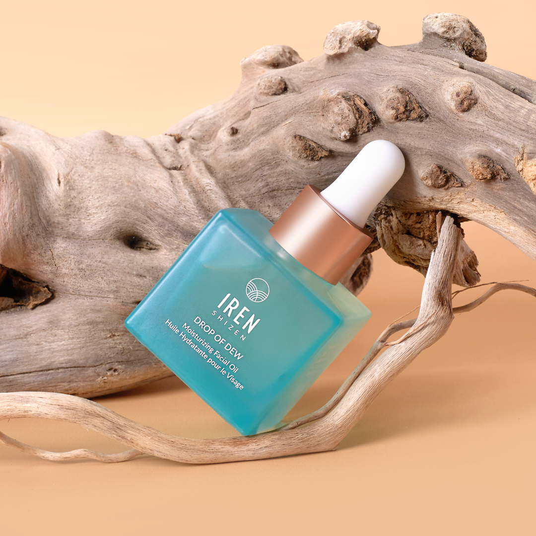 A bottle of Japanese customized skincare, DROP OF DEW Moisturizing Facial Oil, sitting on a piece of driftwood. #all-groups